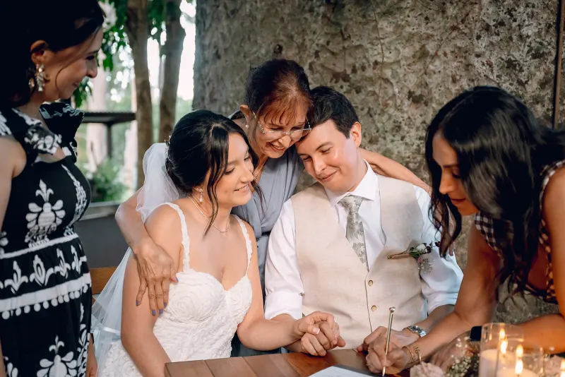Ellie embracing the bride during the wedding certificate signing